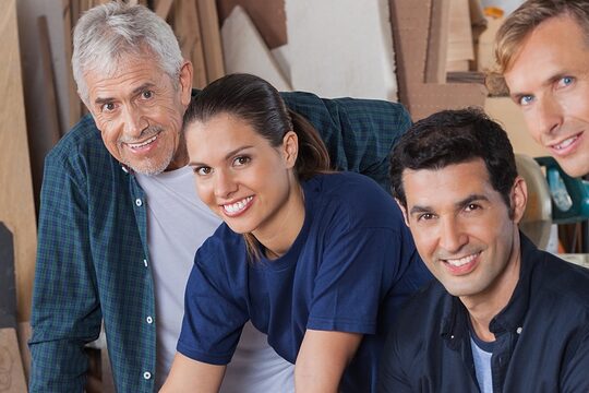 4 Handwerkerinnen und Handwerker schauen in die Kamera. 