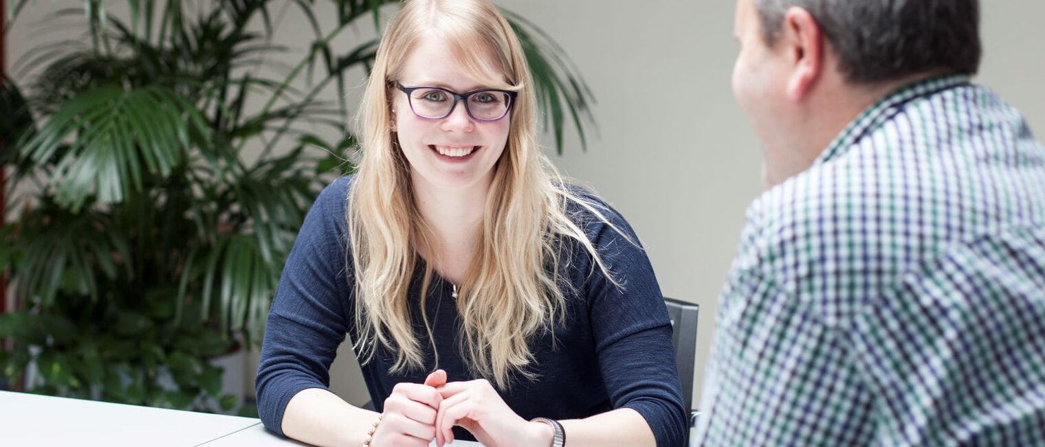 Eine junge Frau im Gespräch mit einem Ausbildungsberater oder Personaler.