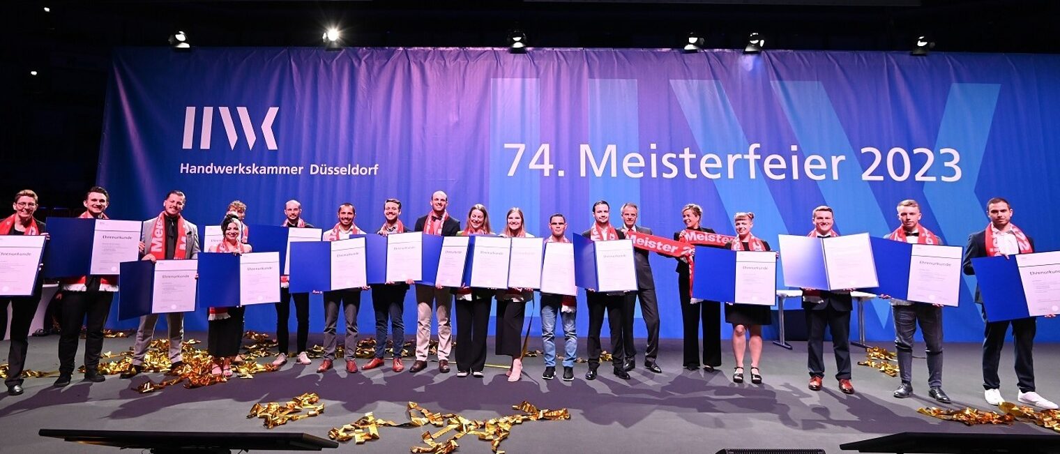 Auf der Bühne: die Jahresbesten mit Ministerin Mona Neubaur und HWK-Präsident Andreas Ehlert 74. Meisterfeier Hwk Düsseldorf v.l.: Jahresbestmeister mit Ministerin Mona Neubaur und Hwk Präsodent Andreas Ehlert