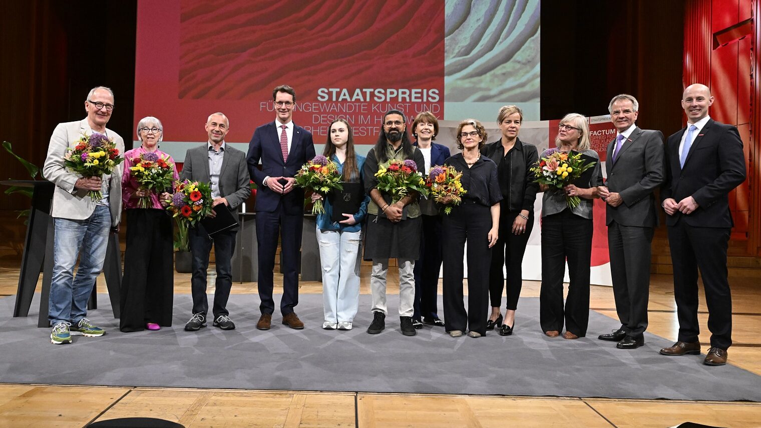 Gruppenbild mit allen Preisträgerinnen und Preisträgern auf der Bühne.