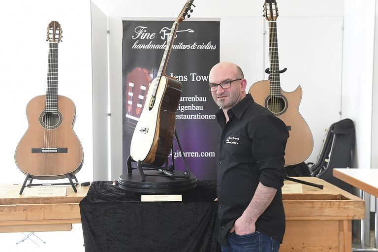 Gitarrenbauer Jens Towet vor seinen Akustik-Gitarren