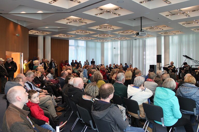 Voll besetzter Konzertsaal beim Auftritt des Trios "The Lucky Ukes"