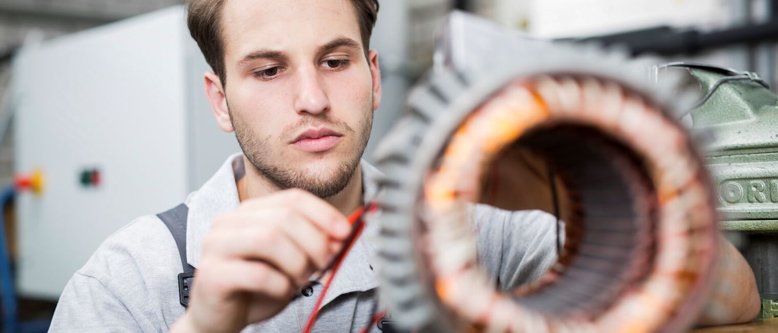 Ein junger Mann verkabelt ein elektronisches Bauteil