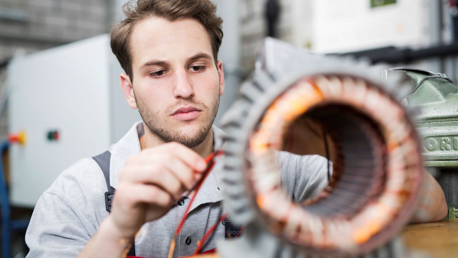 Ein junger Mann verkabelt ein elektronisches Bauteil
