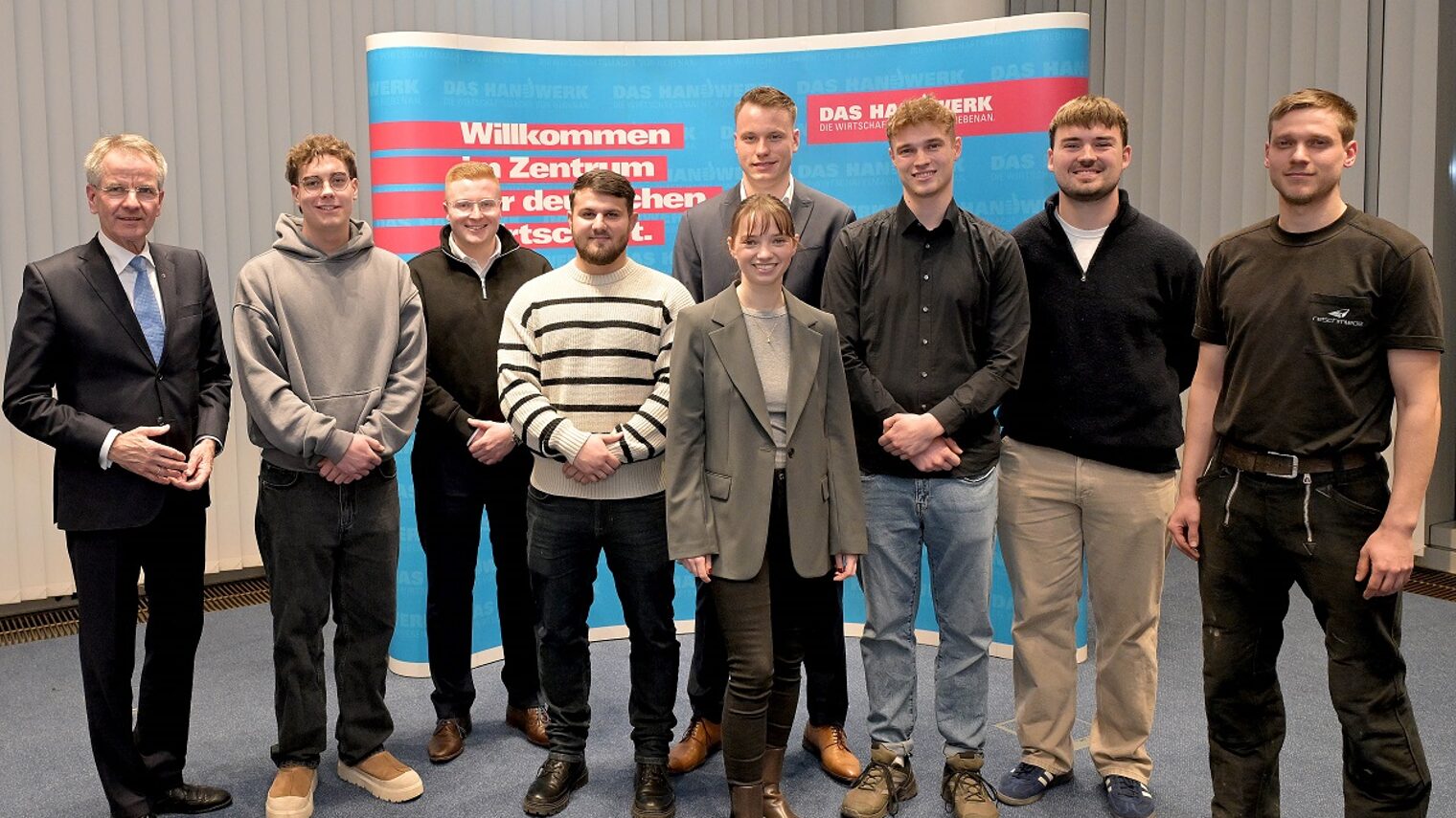 Die Sieger der Deutschen Meisterschaft im Handwerk posieren mit Präsident Ehlert für ein Pressefoto.