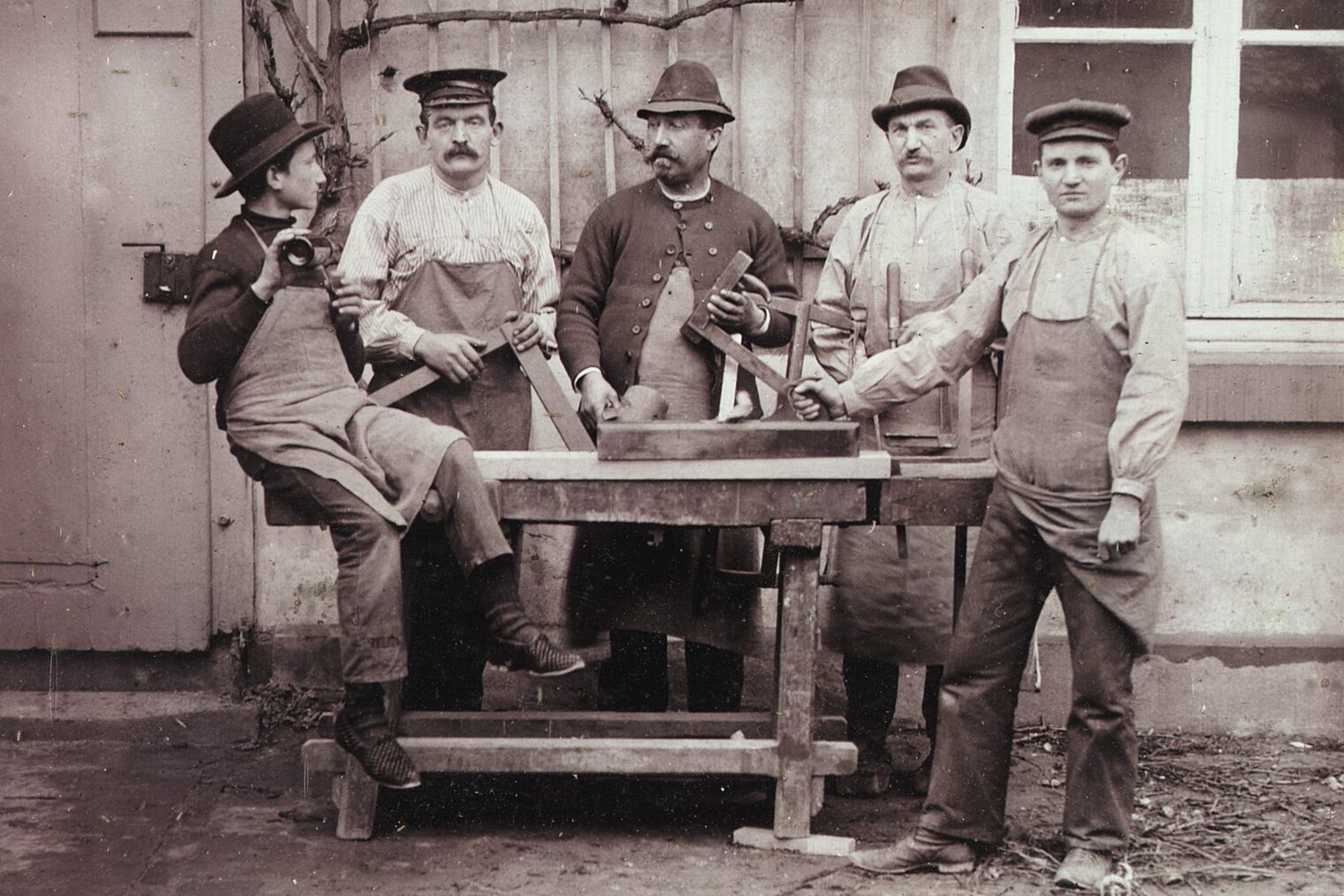Schreinermeister Caspar Kreuer und Mitarbeiter an einer Werkbank in Monheim am Rhein, 1902