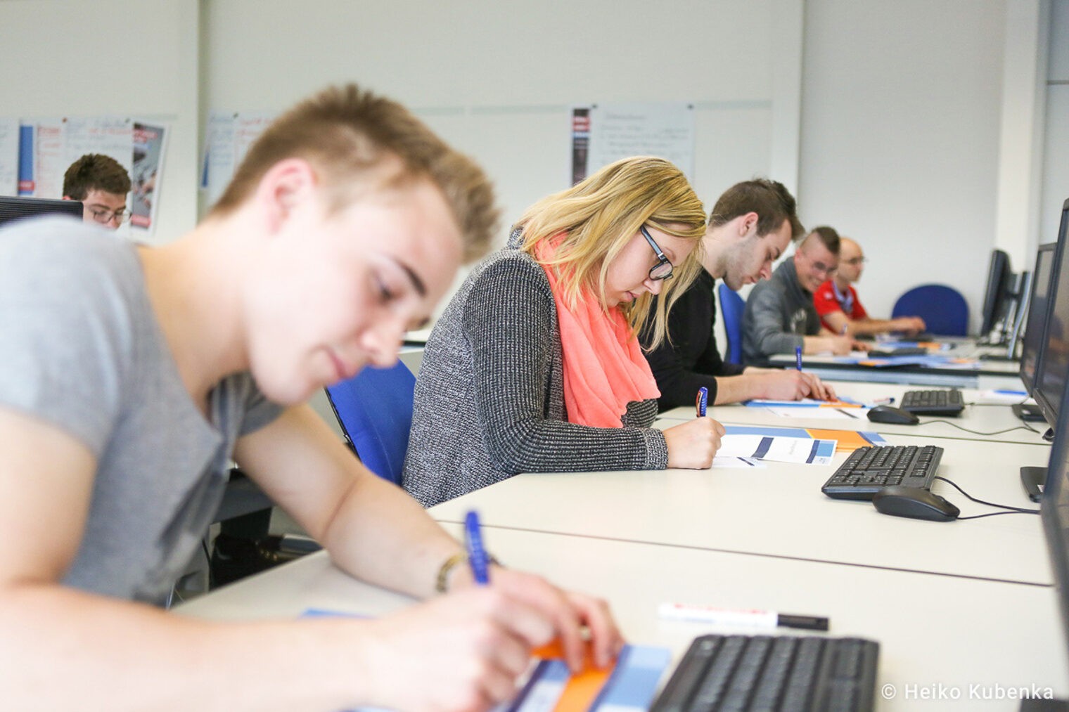 Seminarteilnehmer in einem modernen Schulungsraum Teilnehmer eines Seminars schreiben Notizen an Computertischen