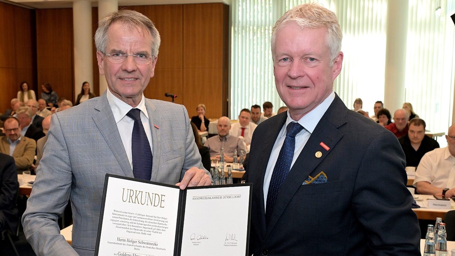 Präsident Andreas Ehlert und Generalsekretär Holger Schwannecke zeigen eine Ehren-Urkunde.