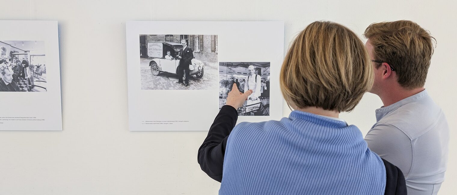 Zwei Betrachter vor Bildern der Ausstellung 125 Jahre Handwerkskammer Düsseldorf