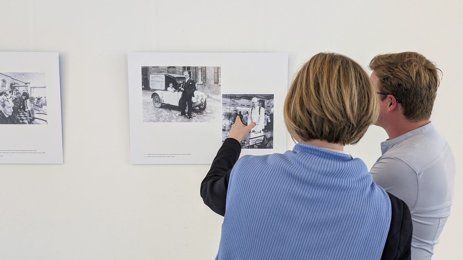 Zwei Betrachter vor Bildern der Ausstellung 125 Jahre Handwerkskammer Düsseldorf