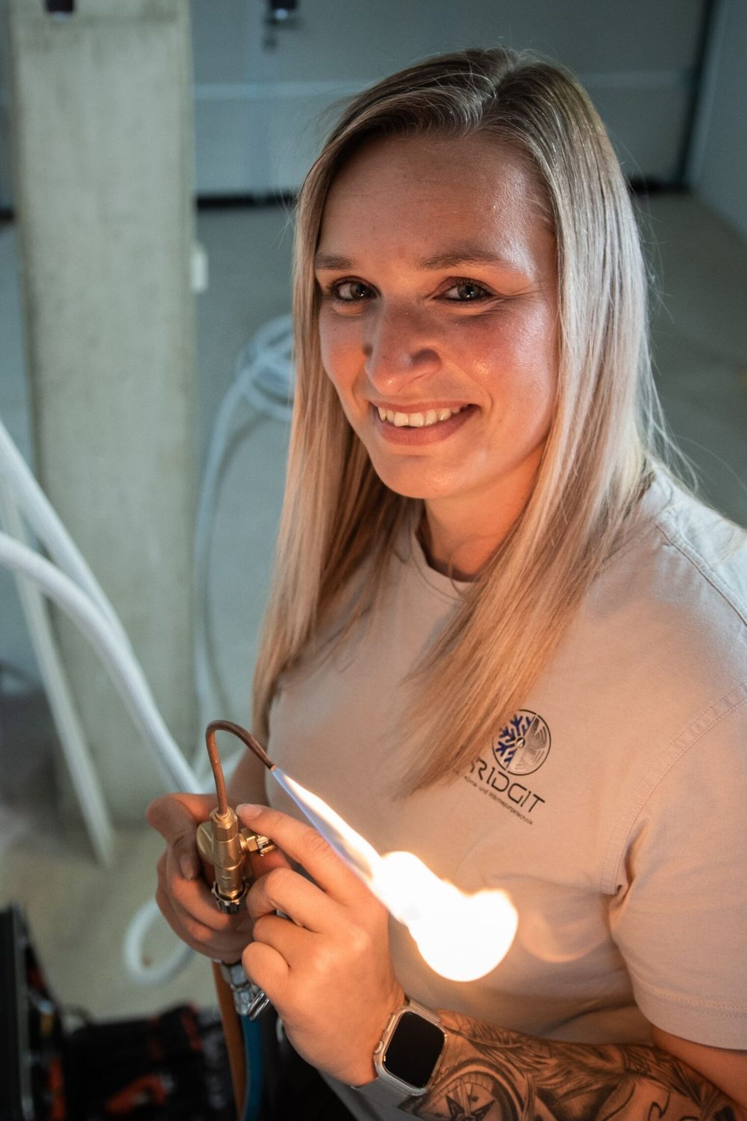 Michèle Boncori mit einer Kabellampe in der Hand lächelt in die Kamera