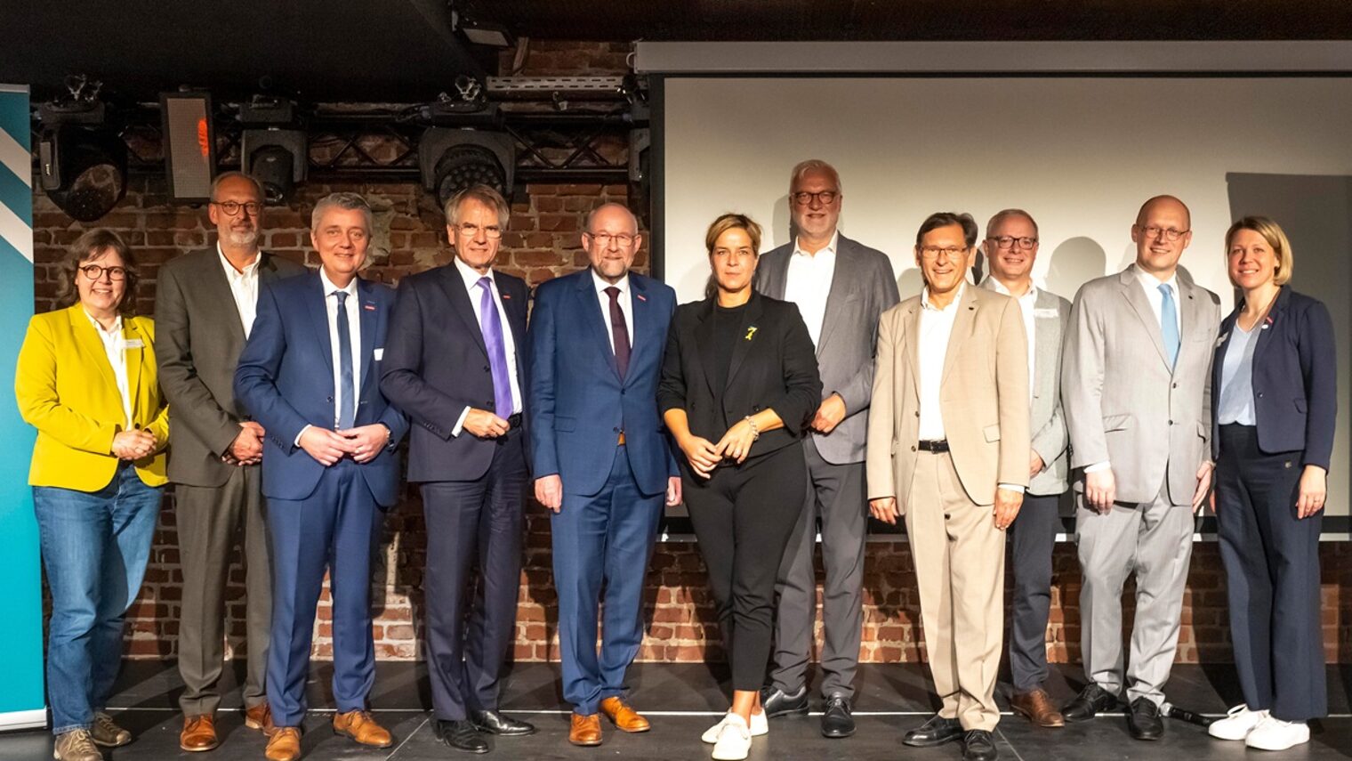 Die Podiumsteilnehmer posieren für ein Pressefoto.
