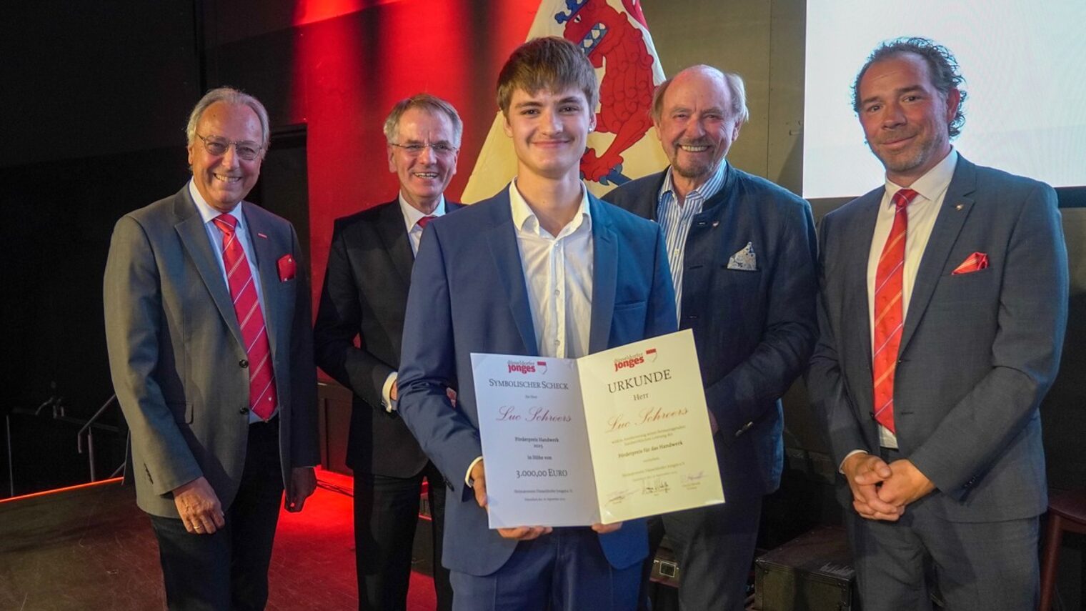 Gruppenfoto mit Preisträger Luc Schroers, der seine Urkunde in den Händen hält.