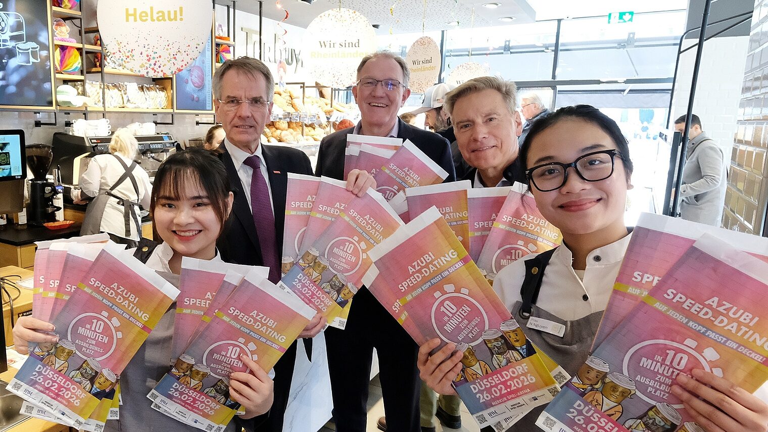 Die Akteure präsentieren stolz die bunt bedruckten Brötchentüten, die auf das Azubi-Speed-Dating hinweisen.