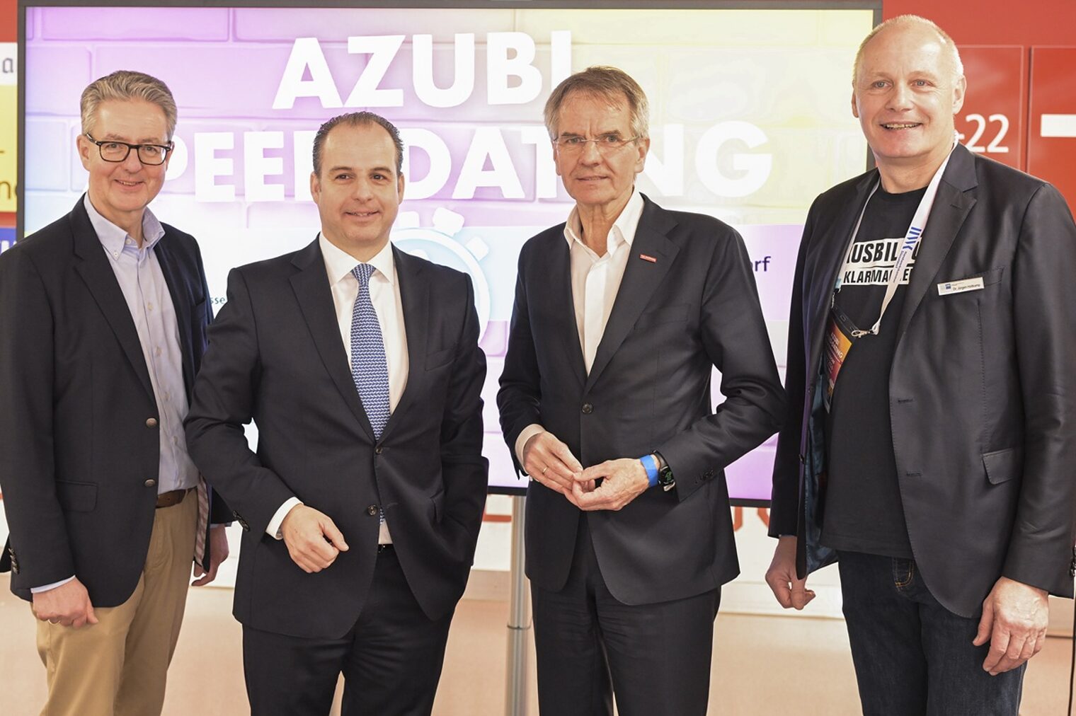 Die Akteure posieren vor einem Presse-Hintergrund, der auf das Azubi-Speed-Dating hinweist.