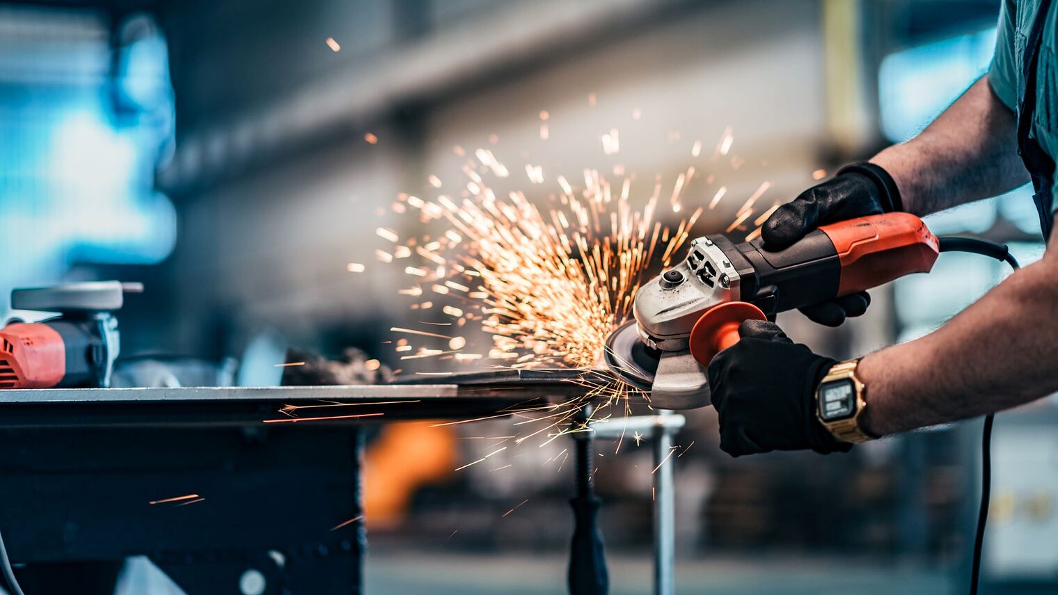 Schneiden von Metall mit Scheibenschleifer in der Werkstatt, Nahaufnahme.